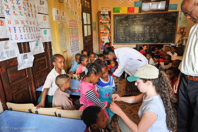 20120328_111713 Nikon D3 2x3.jpg - Hannah is a 16 year old American girl who was part of the US delegation.  Here Hannah is placing bracelets on the school children's wrists.